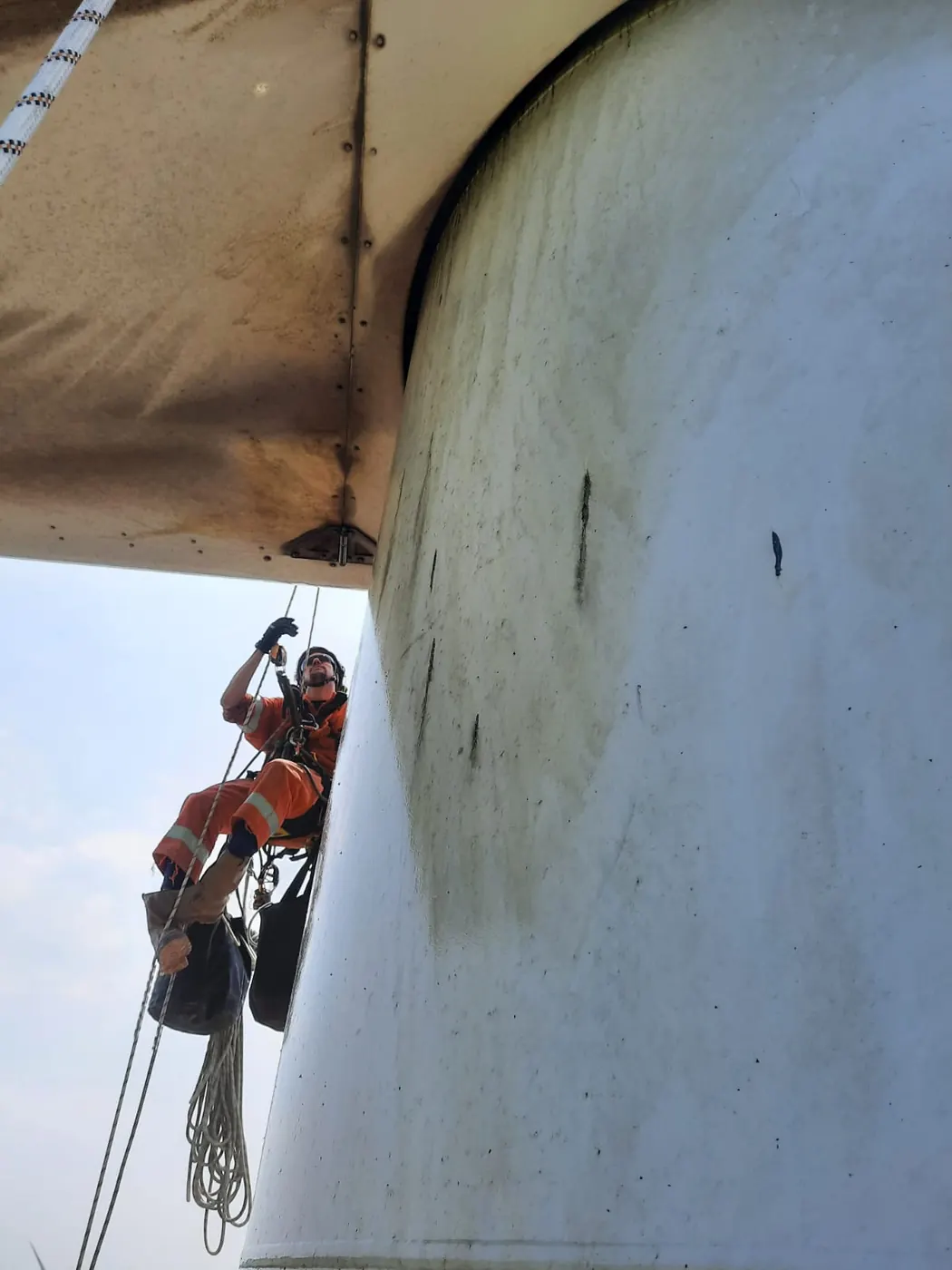 Technicus aan het touw onder de gondel van een windturbine